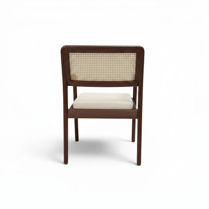 Gharnish Vanya Teakwood Cane Chair with natural cane back and seat, brown polish, and cream cushion.