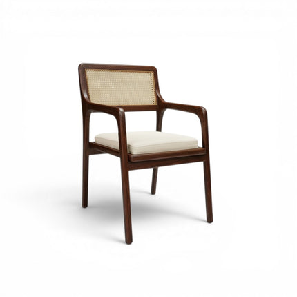 Gharnish Vanya Teakwood Cane Chair with natural cane back and seat, brown finish, and cream cushion.