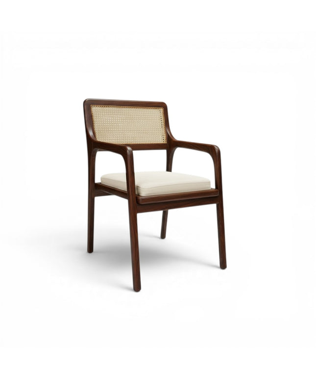 Gharnish Vanya Teakwood Cane Chair with natural cane back and seat, brown finish, and cream cushion.